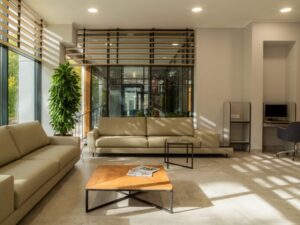 A spacious and modern living room with large windows and natural sunlight illuminating the sleek interior design.